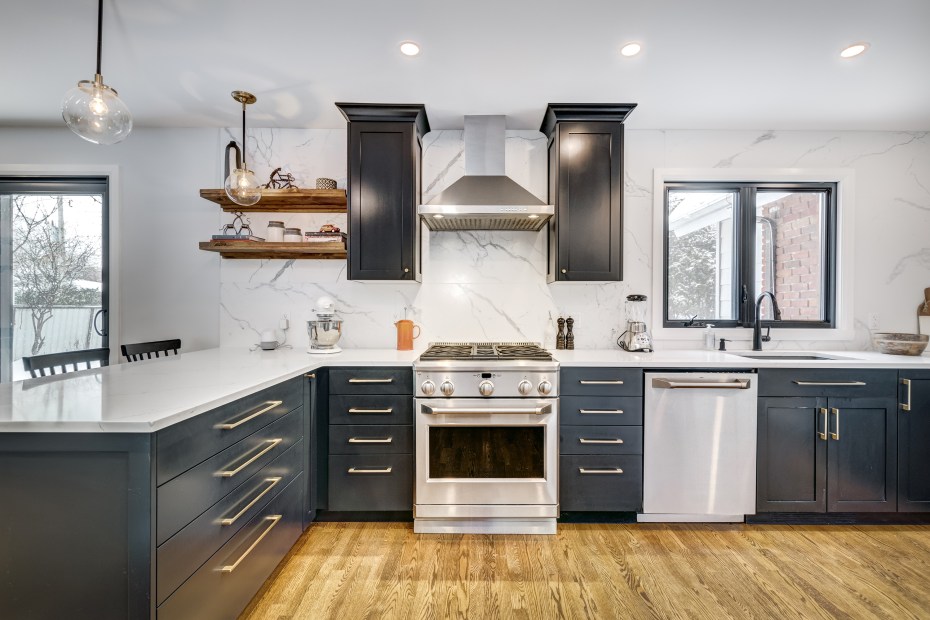 Modern, recently renovated kitchen with white counters and dark navy cabinets.