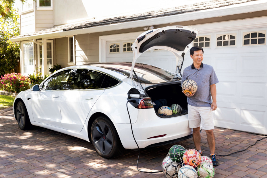 Khoi Tran stands next to his Tesla Model 3.