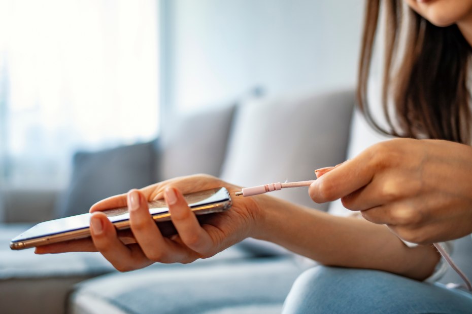 A woman plugs in her phone to charge.