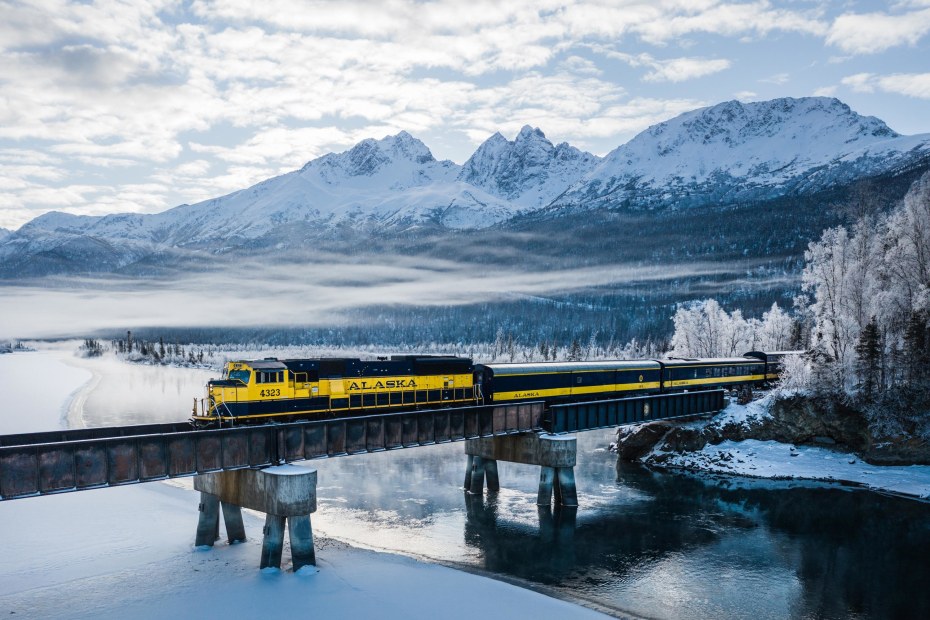 Aurora Winter Train from the Alaska Railroad crosses a frozen river.