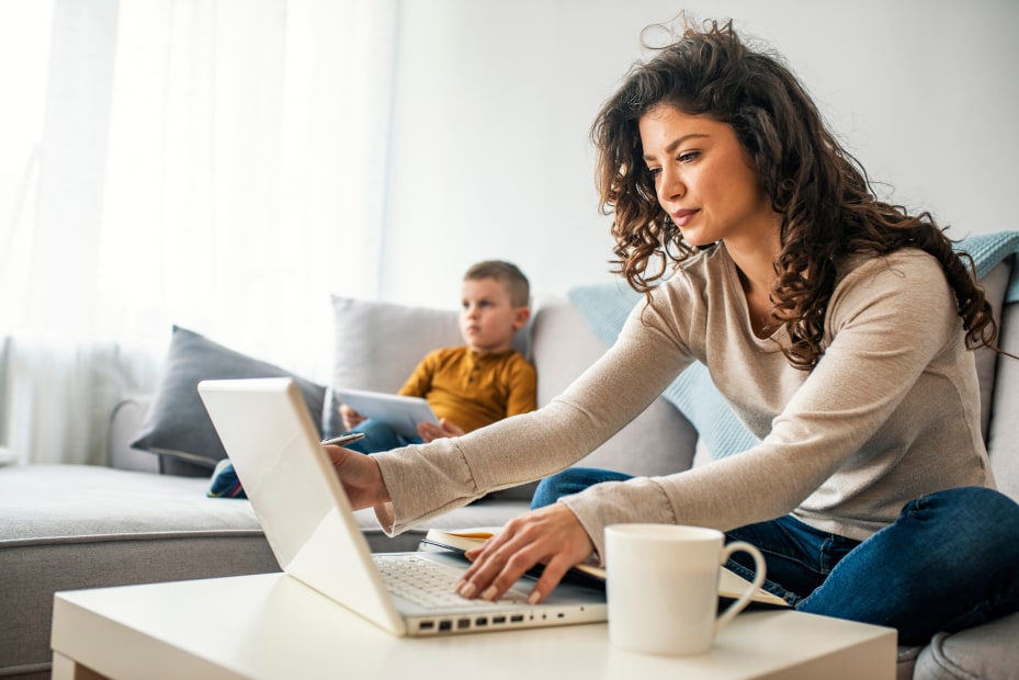 A woman enters her password on her computer.