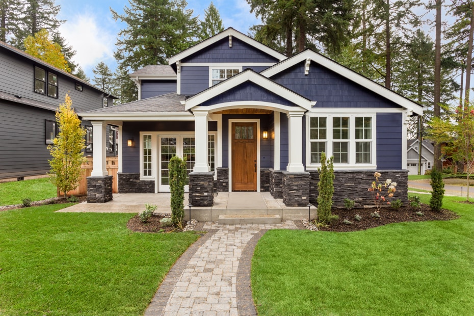 A blue, modern craftsman on a sunny day.