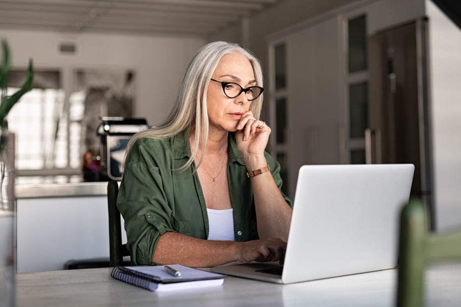 A senior woman reviews her retirement portfolios online.