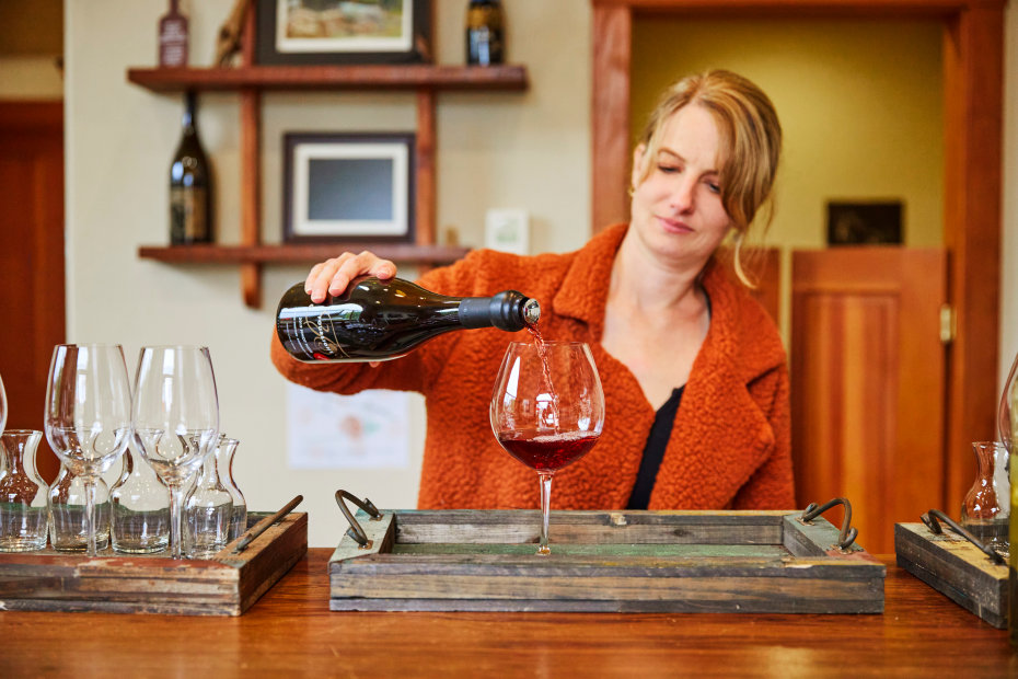 A woman pours wine inside the Foursight Wines tasting room.