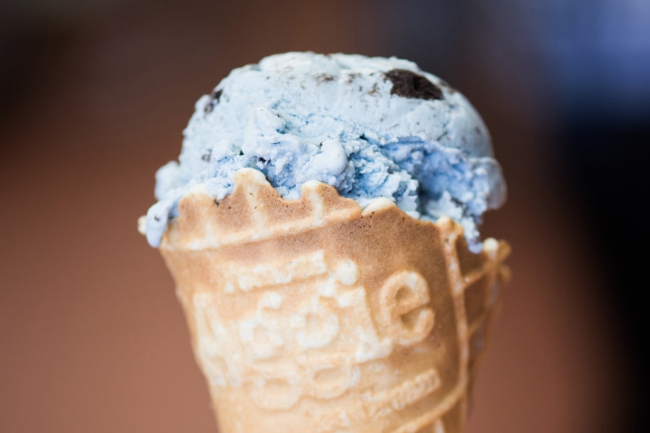 A scoop of Aggie Ice Cream blue mint ice cream in a cone.