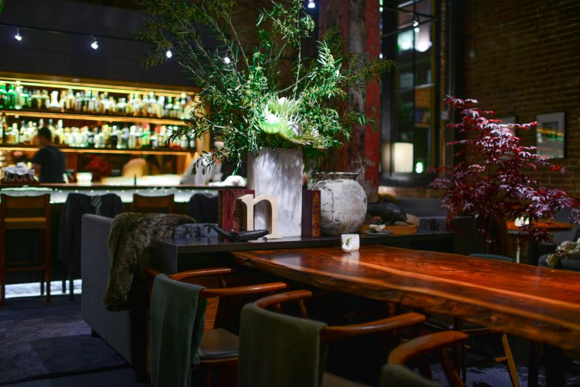 The dark dining room with the bar in the background at Saison in San Francisco, picture