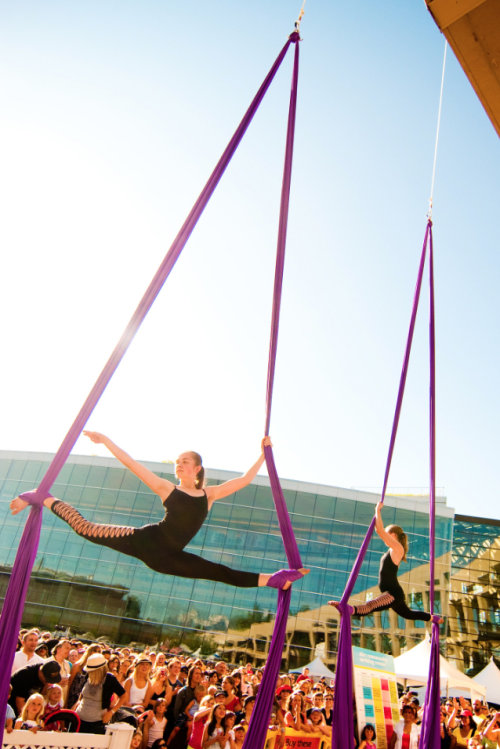 Two aerial artists performing over a crowd at the Utah Arts Festival, photo