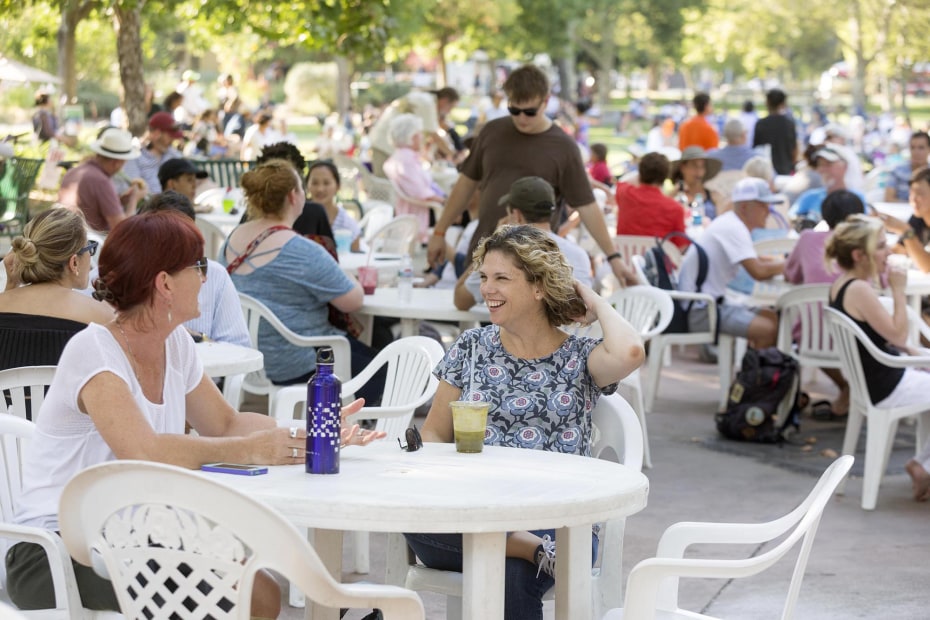 People sit at tables during Picnic in the Park in Davis, California, image