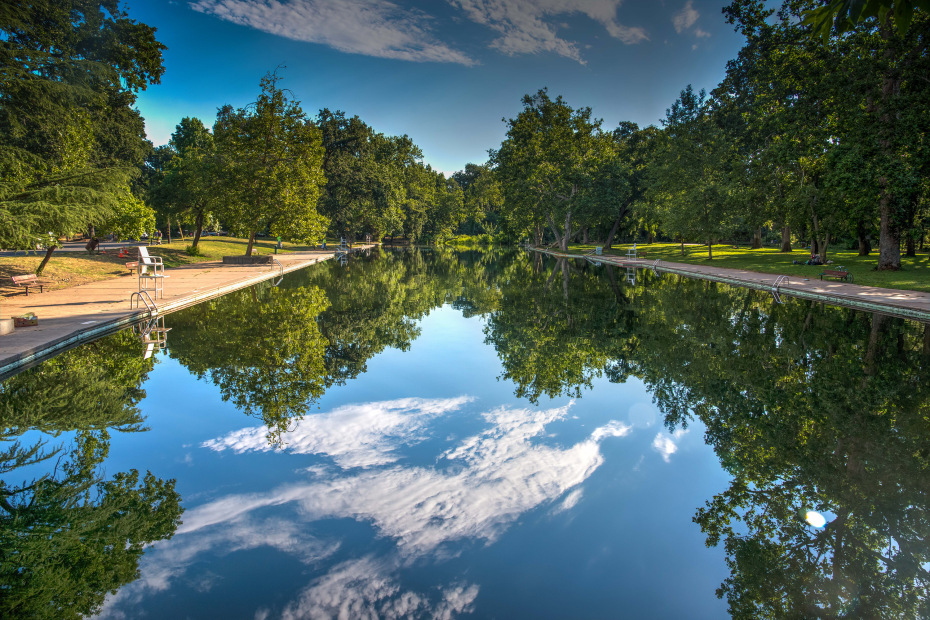 The trees and clouds reflected in the still Sycamore Pool along the Big Chico Creek in Bidwell Park in Chico, CA, image