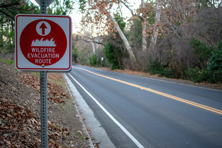 Wildifre evacuation route sign on the side of a rural road.