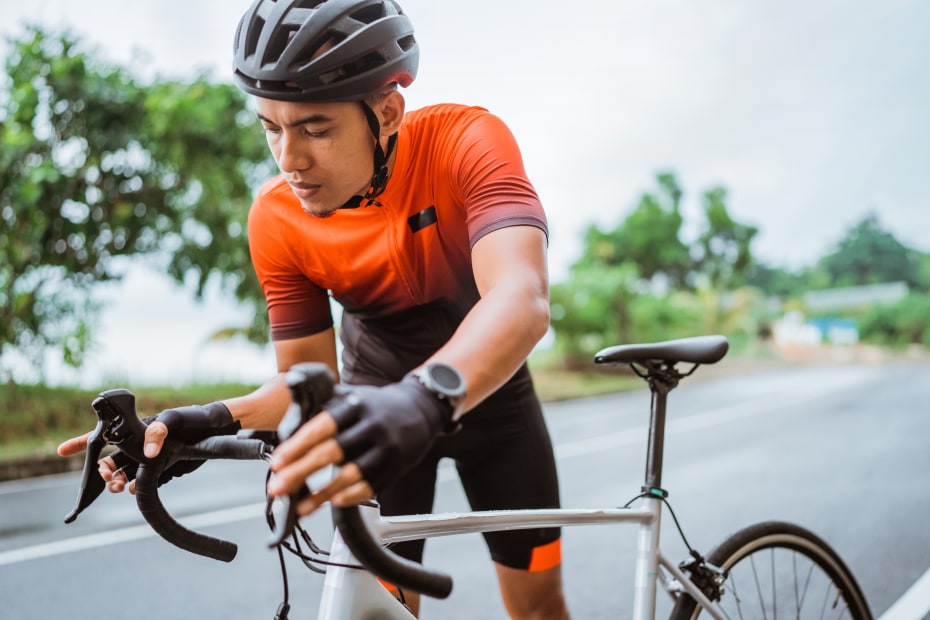 A cyclist checks his brakes before heading off for a road ride.