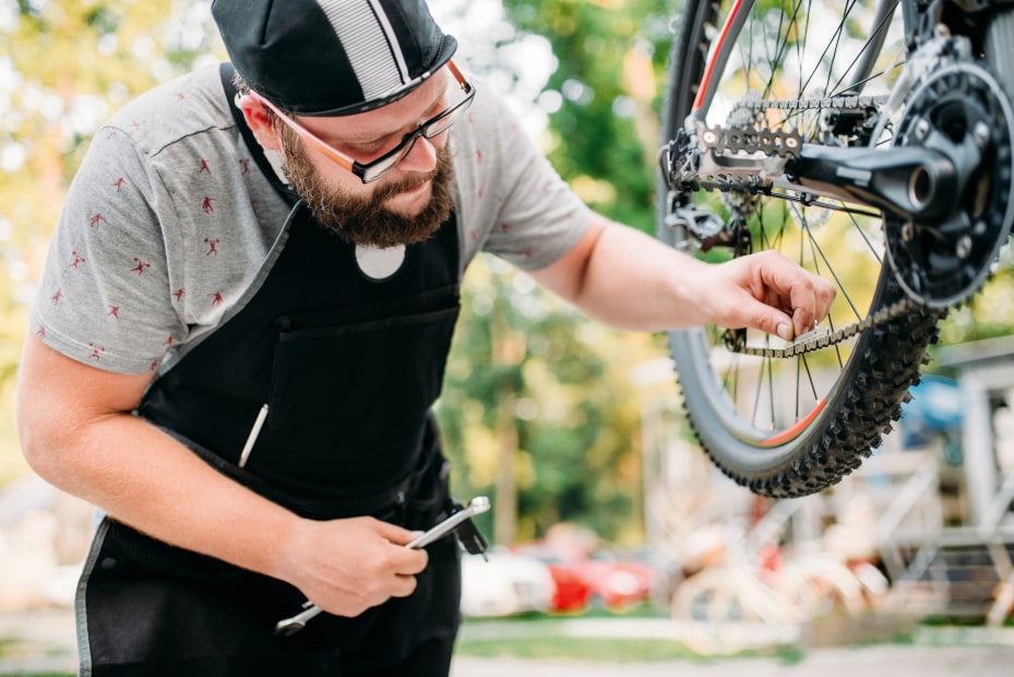 A bike mechanic measures a road bike chain.