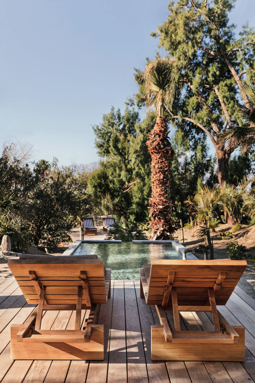 a pair of empty chaise lounges overlooking a mineral pool at Two Bunch Palms in Palm Springs