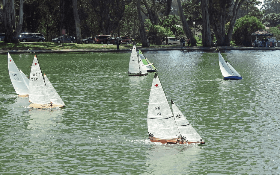 model boats ride the water as part of the Model Yacht Club in Golden Gate Park