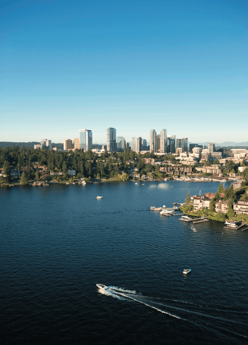 a boat glides along Lake Washington with the Seattle skyline in the background