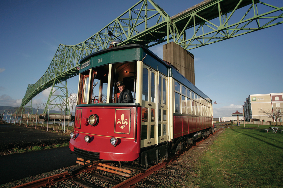 the red Old 300 trolley below the Astoria bridge on the Astoria Riverwalk