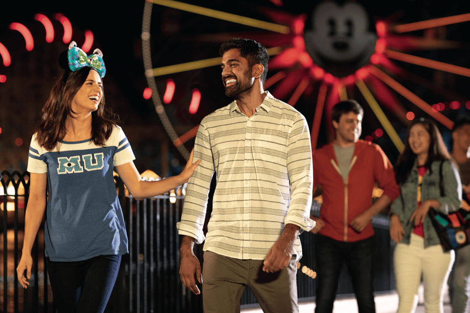 a couple laughs while walking through Disney California Adventure at night