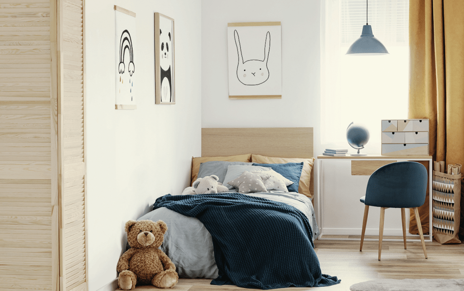 a neat bedroom with a single bed draped in a blanket beside a desk with chair