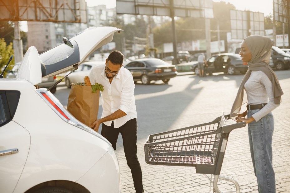 A couple put groceries in their Nissan Leaf.