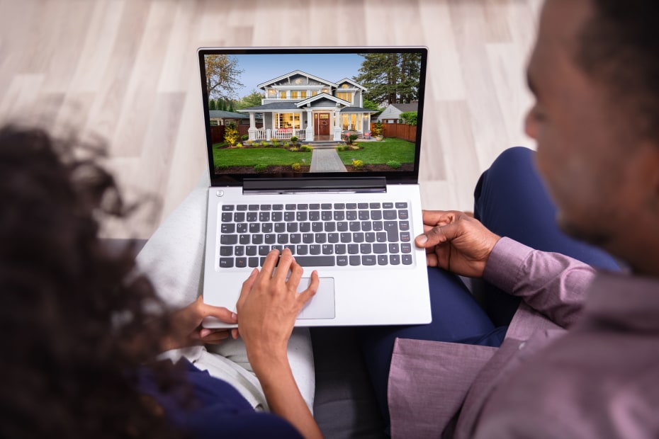 A couple look at a house listing on their computer.