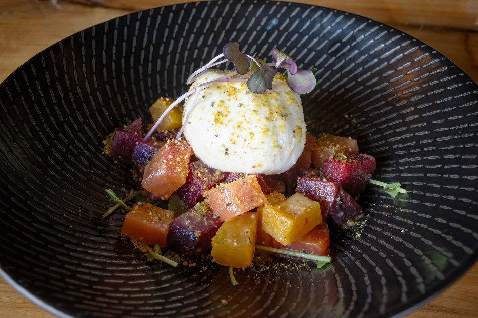 Roasted beets with buratta on a black plate from 3 Spear Ranch.