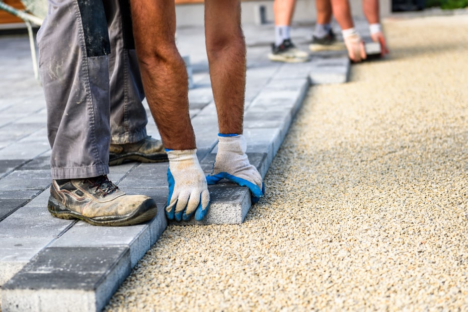 Contractors lay down permeable pavers on top of crushed rock.