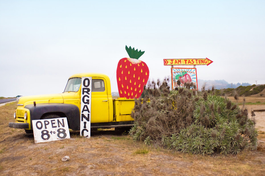A vintage yellow truck with hand-painted signs mark the entrance to Swanton Berry Strawberry Farm outside Santa Cruz, California.