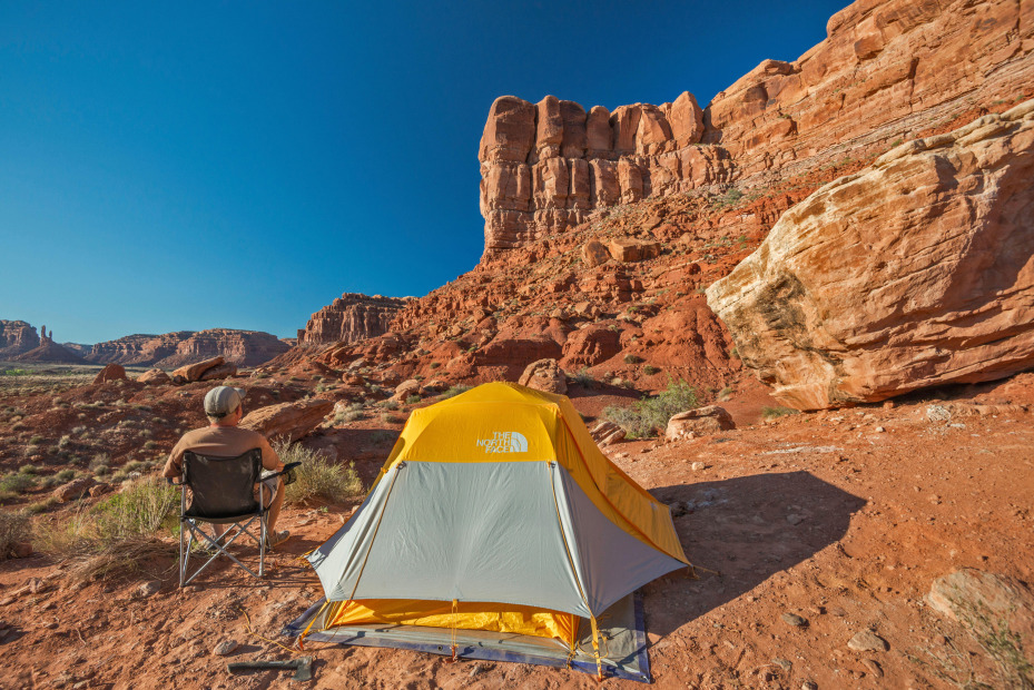 A man sits next to his tent in Valley of the Gods in Bears Ears National Monument.