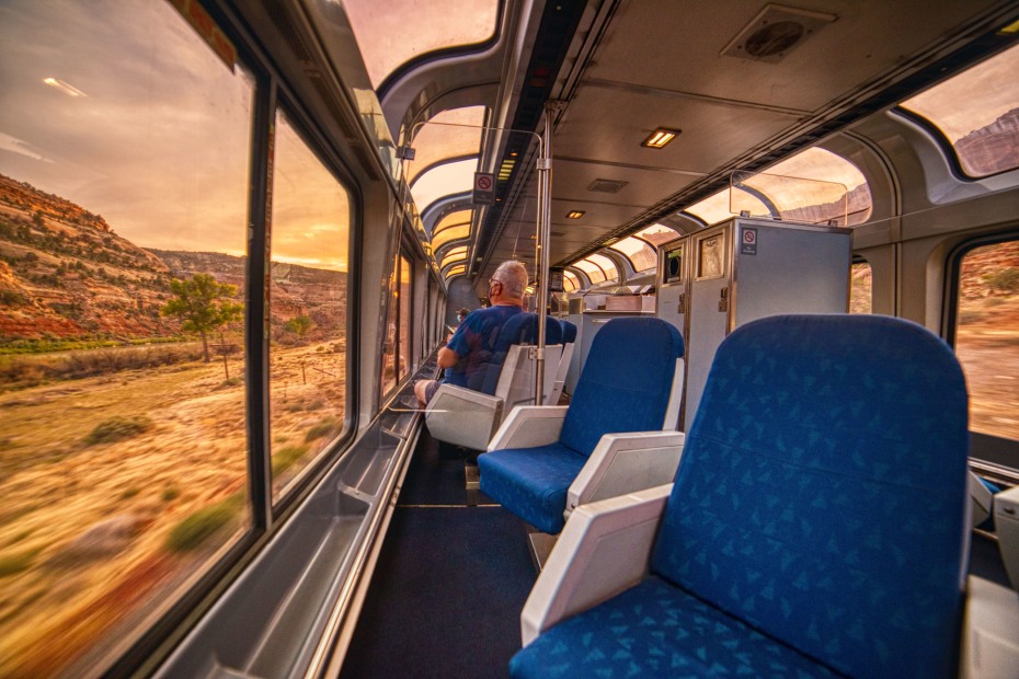 Inside an Amtrak train crossing through the Rocky Mountains in Colorado with fall colors visible out the window.