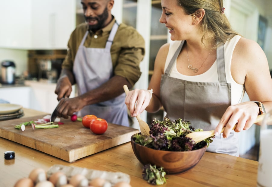 A couple prepare a salad together.