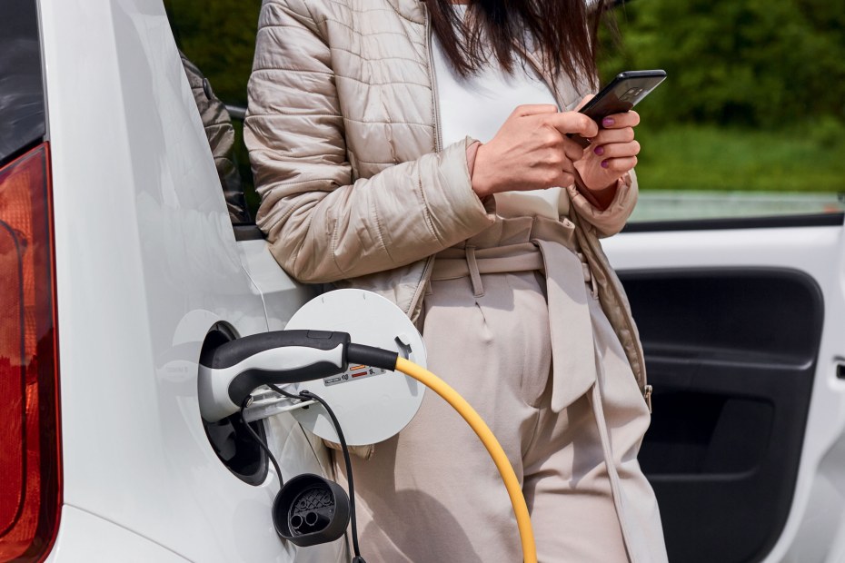 A woman charges her EV with a phone app.