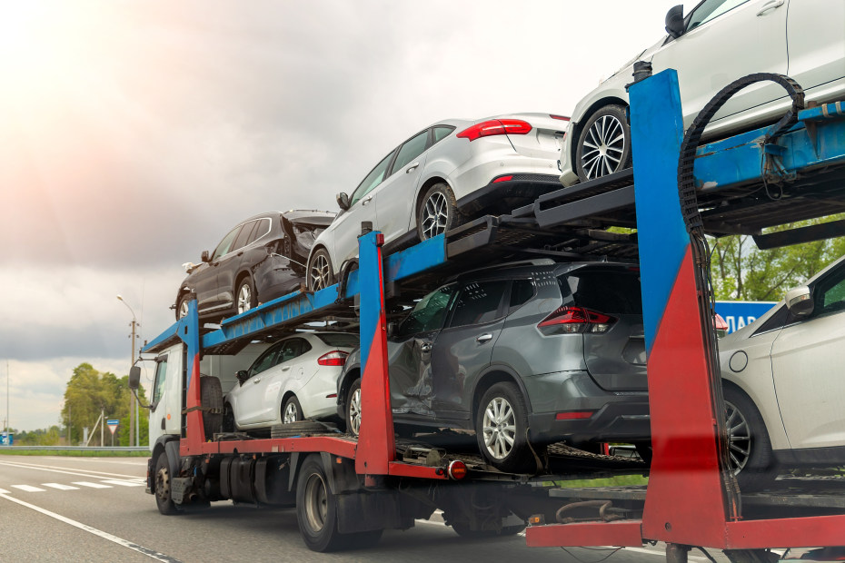 Totaled, salvaged cars on a semi trailer.