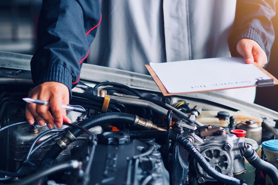 A mechanic inspects a vehicle's engine.