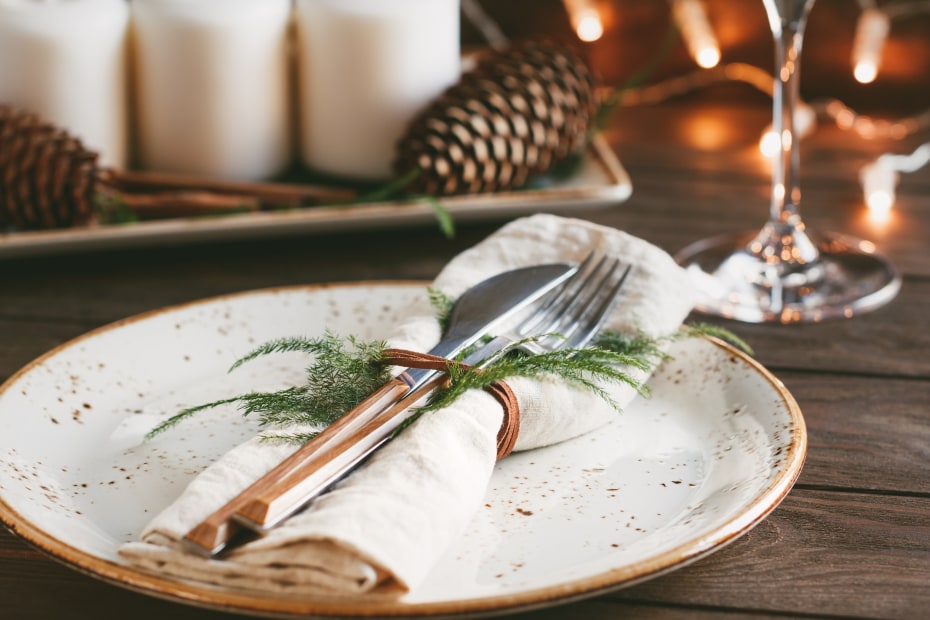 Evergreen twigs and pine cones decorate a holiday table