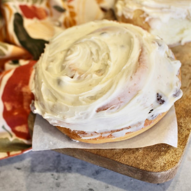 A fully frosted cinnamon roll on a wood tray at Lehi Bakery in Lehi, Utah.
