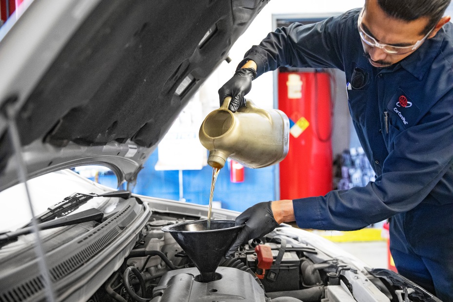 A AAA Auto Repair mechanic replaces the oil on a car.