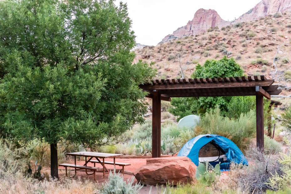 Watchman Campground campsite with a blue tent under the pergola next to the picnic table.