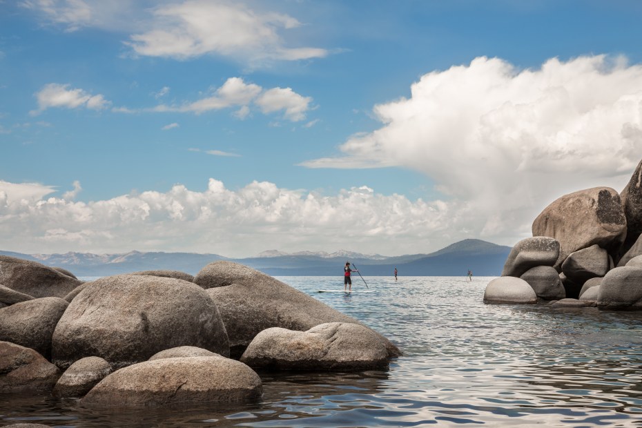 A small group paddleboards around the large boulders in Lake Tahoe's Sand Harbor State Park.