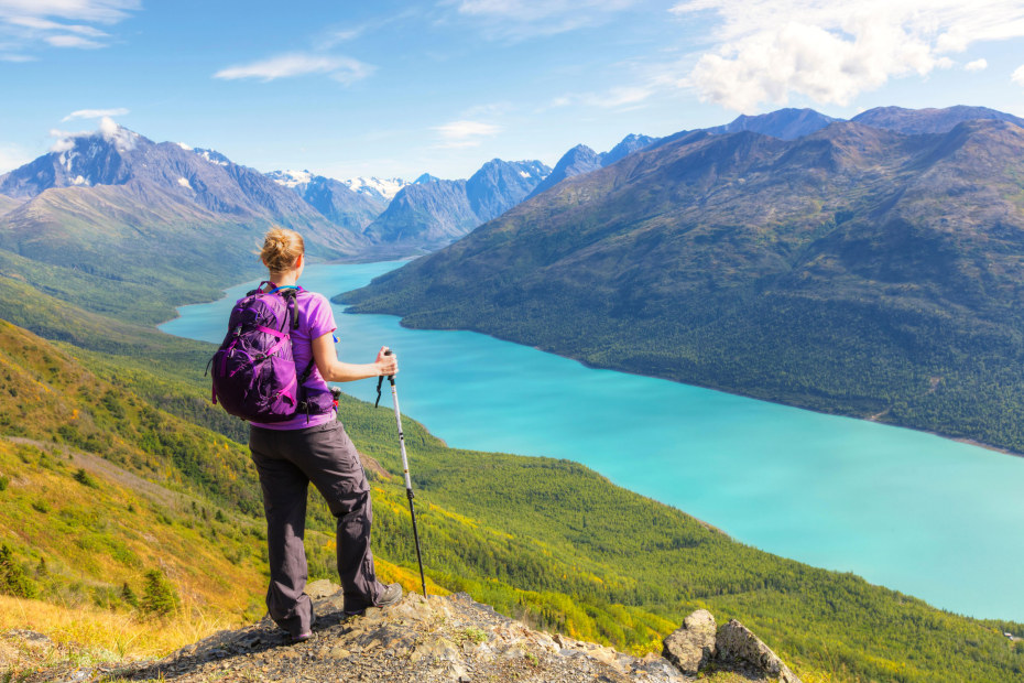 A hiker looks out over Eklutna Lake from Twin Peaks Trail in Alaska's Chugach State Park.
