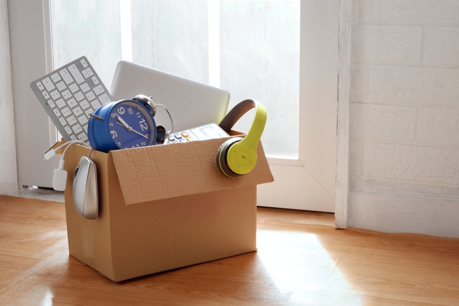 Obsolete electronic gadgets and e-waste in a cardboard box.