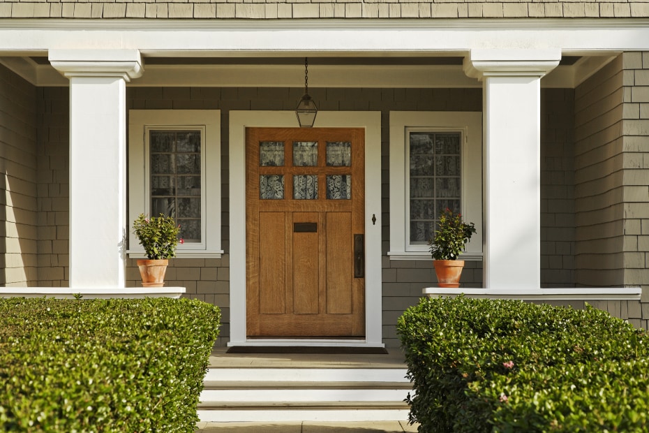 Bushes frame a traditional front porch.