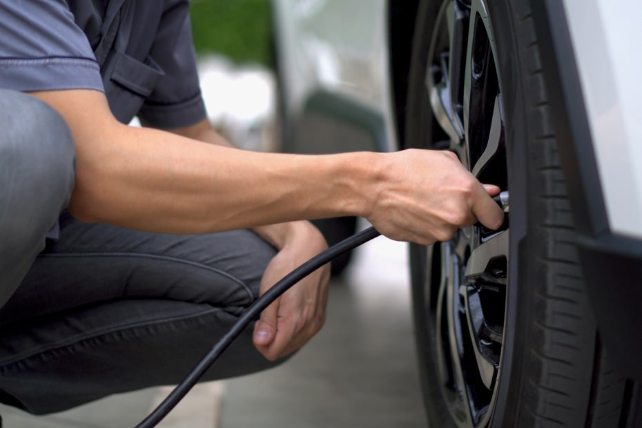 A driver inflates his tires to the recommended PSI.