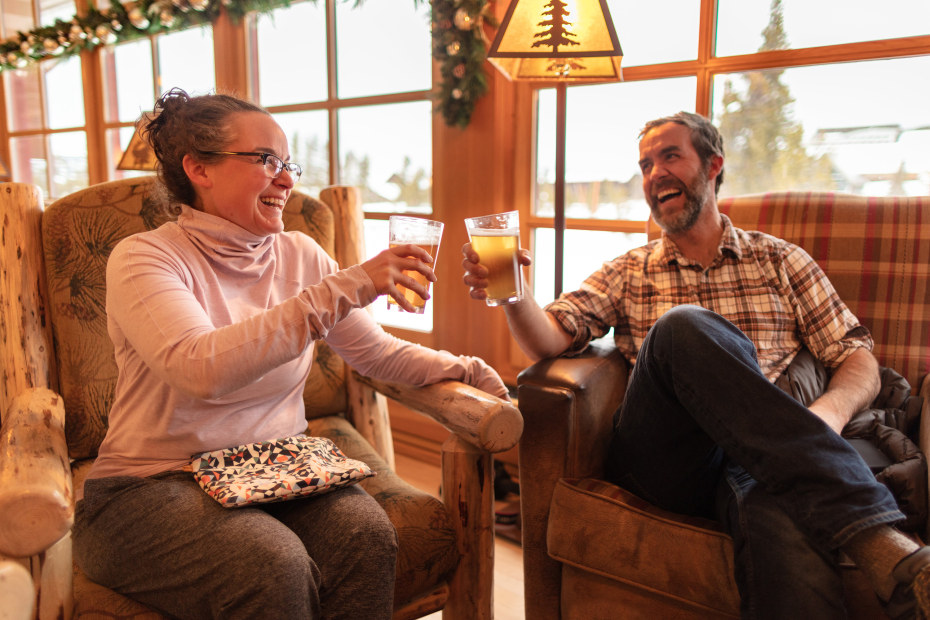 A couple cheers their beers inside the Old Faithful Snow Lodge in Yellowstone National Park.