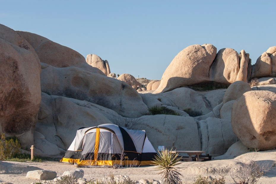 A large tent in a campsite surrounded by rocks in Jumbo Rocks Campground in Joshua Tree National Park.