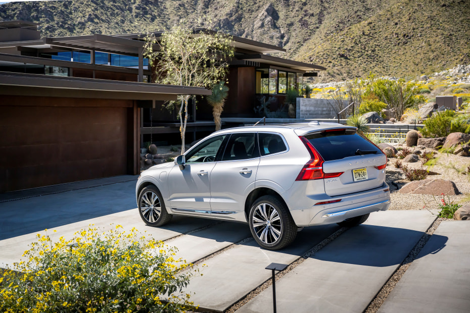 A Volvo XC60 Recharge plug-in hybrid parked in front of a modern desert home.