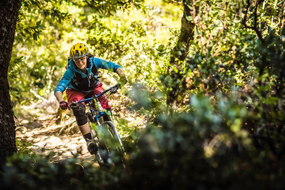 Young woman mountain biking in Soquel Demonstration State Forest in Santa Cruz, California.