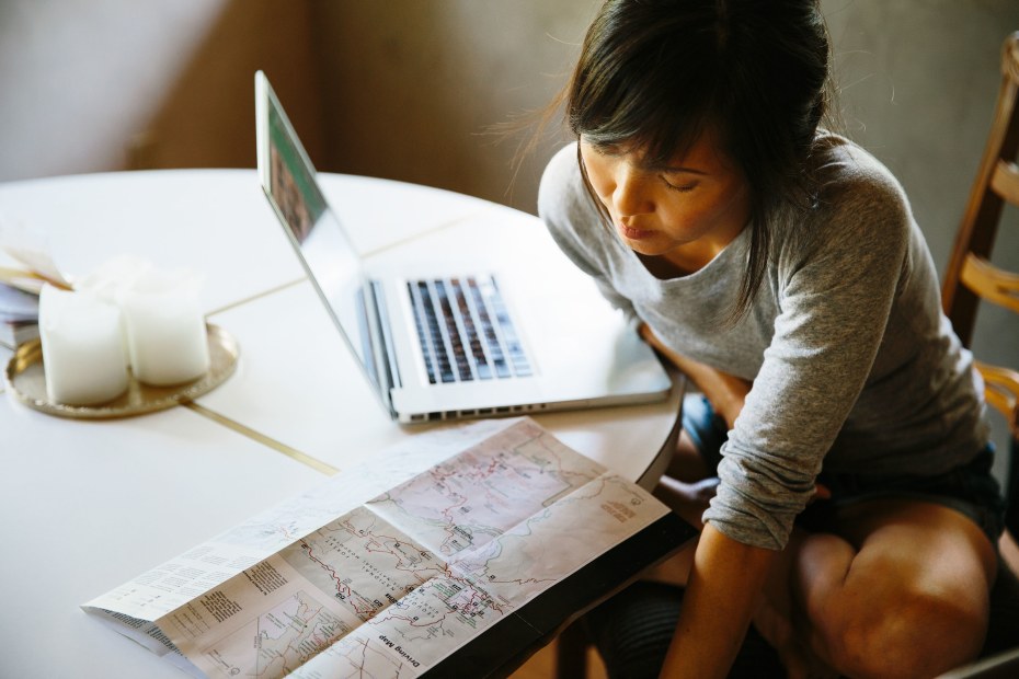 A woman looks a park map while planning a camping trip.