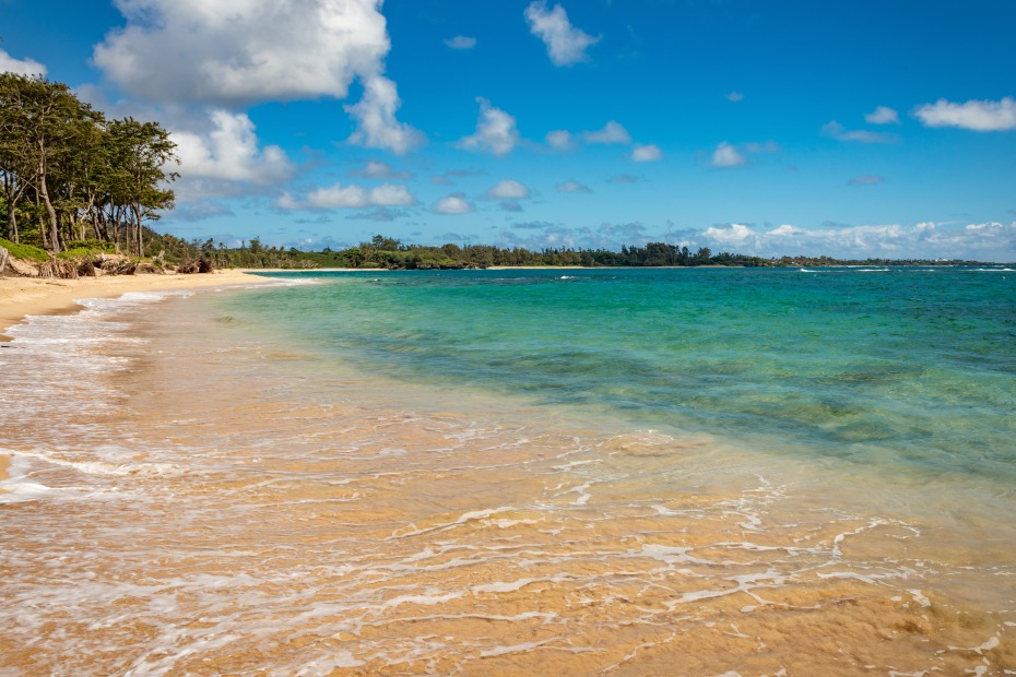 A wave breaks across the beach at Hawaii's Malaekahana State Recreation Area.