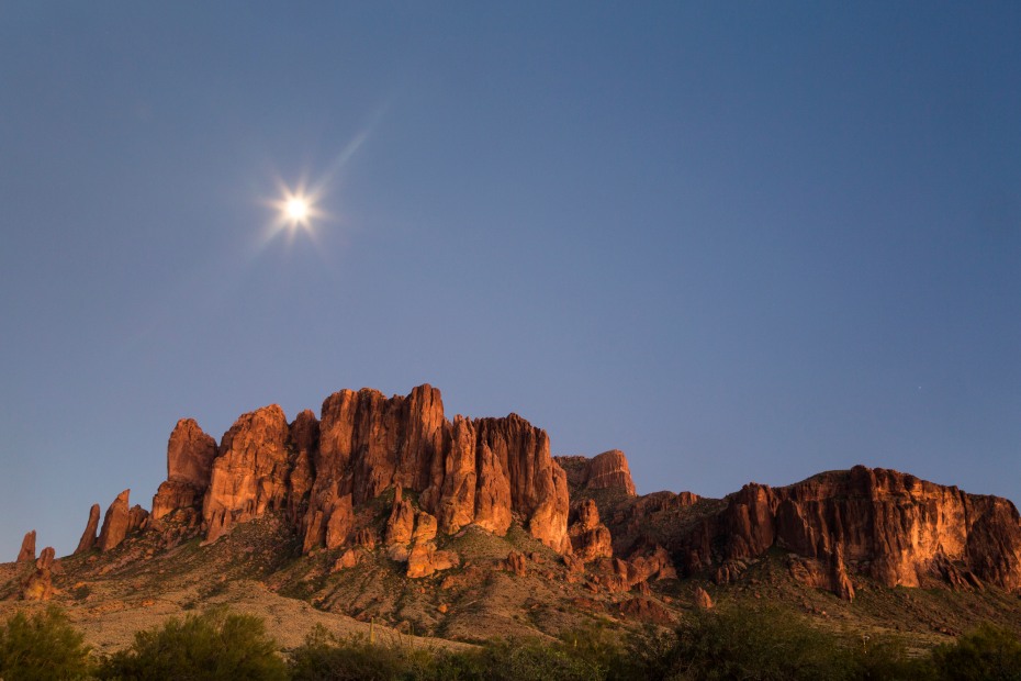 The moon rises over the mountains in Lost Dutchman State Park.