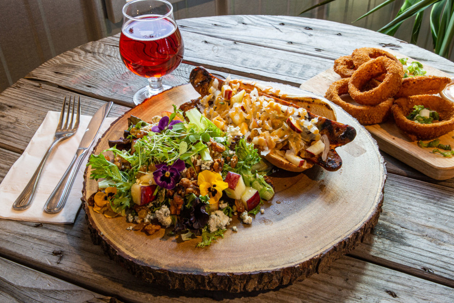 The bratwust with apple and walnut side salad, onion rings, and a glass of cherry cider at Big Mountain Ciderworks.